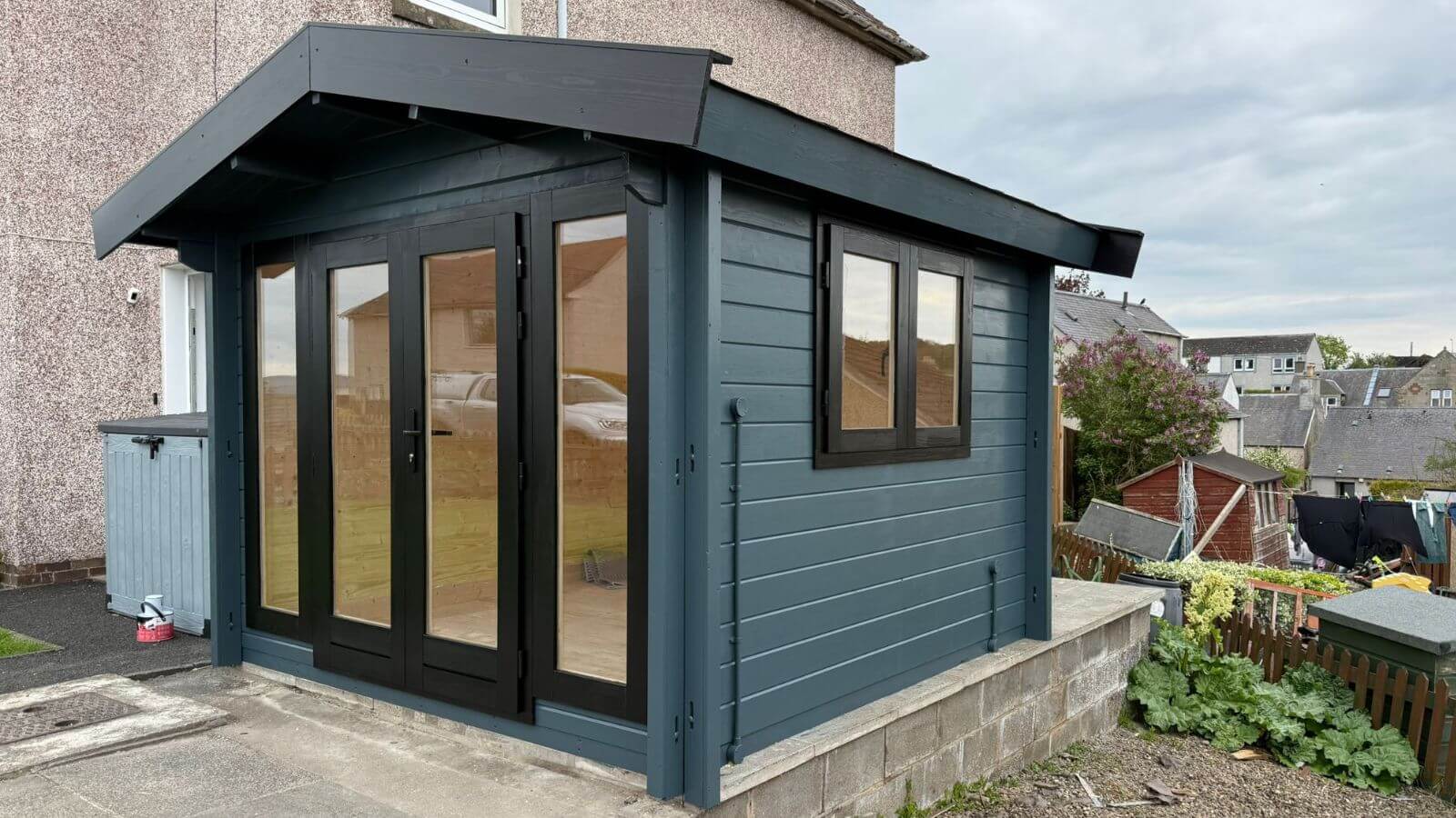 Small timber log cabin in customer garden
